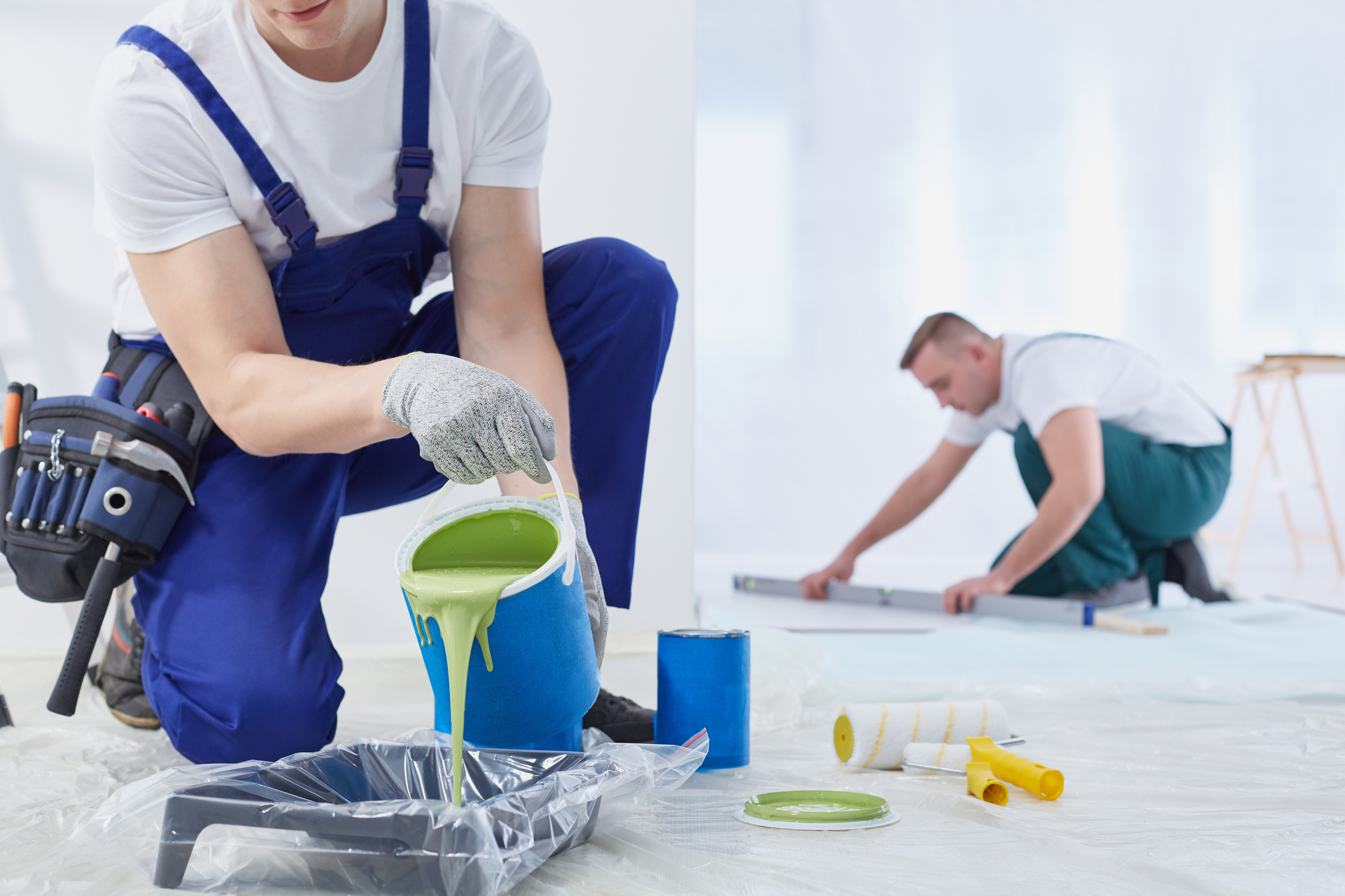 Painter pouring paint into tray