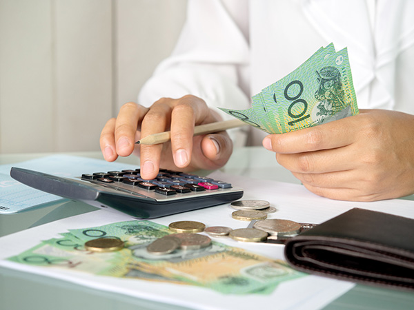 Accountant woman counting an australian money and using calculator for accounting concept.